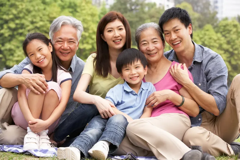 Three generations of a family smiling outdoors